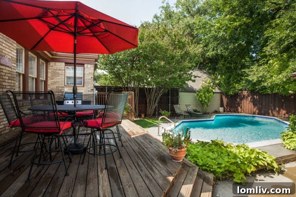 Another view of the backyard pool area, highlighting the outdoor living space and a small patch of green lawn.