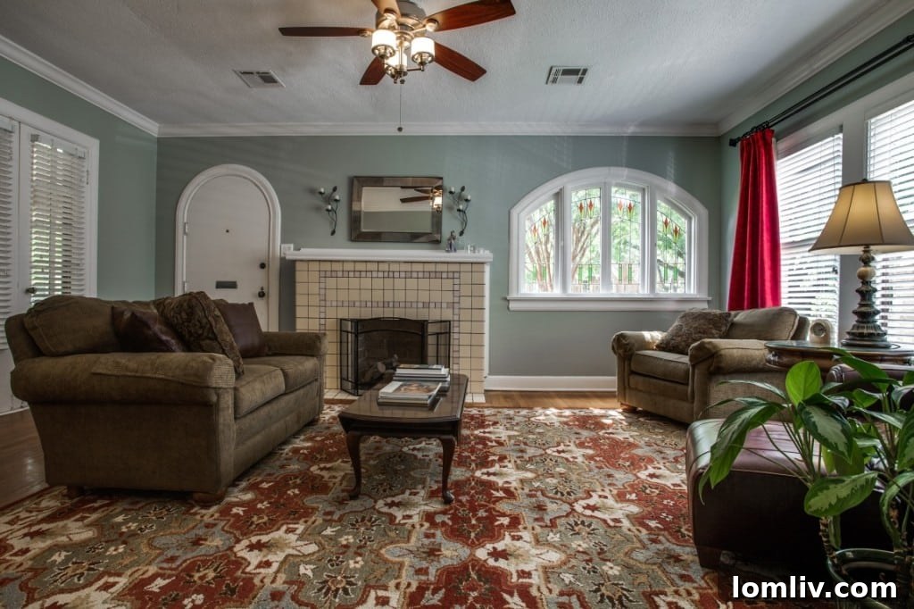 Cozy living room interior of the Tudor home, highlighting the fireplace and hardwood floors.