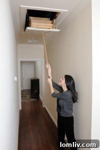 Attic Ease solid oak reach hook in use, demonstrating easy attic ladder operation