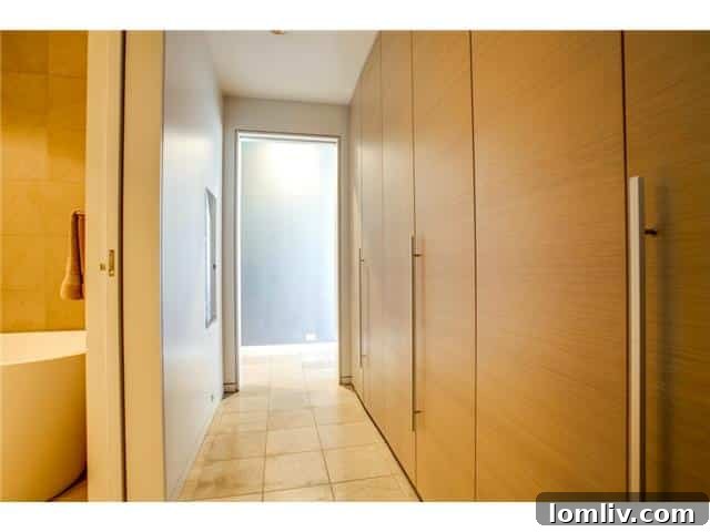 Ample and elegantly designed closet space lining the hallway in Unit 2001, offering practical storage solutions.