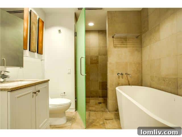 Opulent master bathroom in Unit 2001, featuring a free-standing soaking tub and a spacious stone shower.