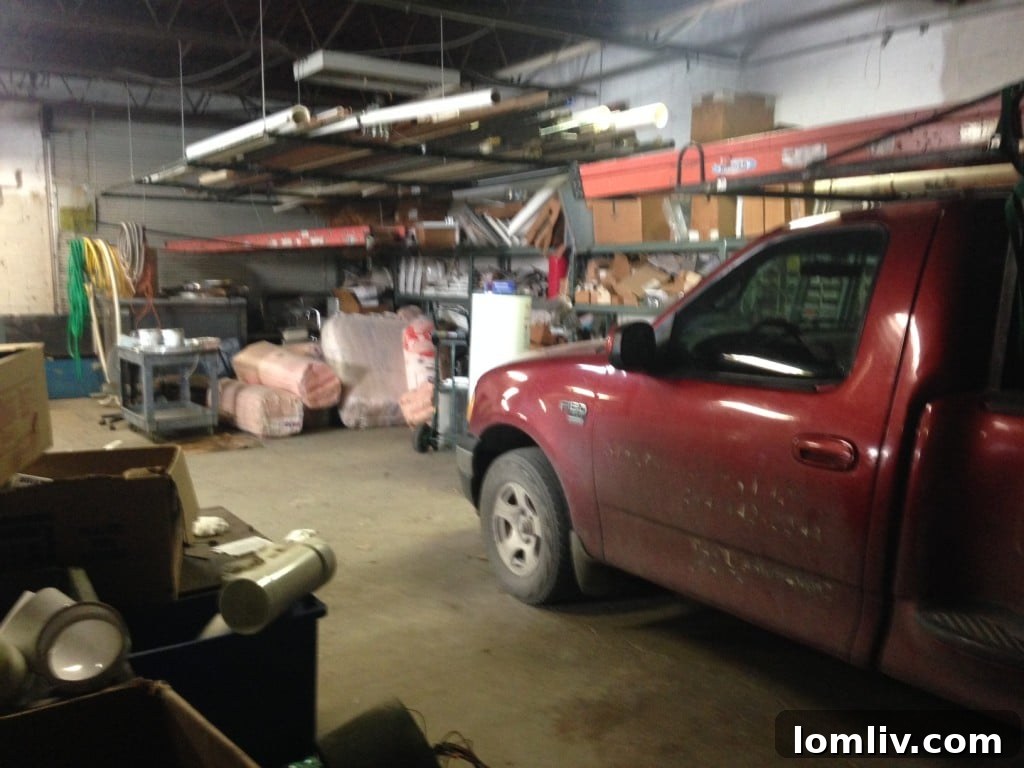 Another angle of the unrenovated garage, showing tools and discarded items