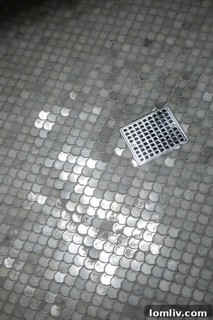 Intricate fish scale marble tile in the upstairs shower of Stacey Warnix's home, adding a touch of vintage charm and sophisticated texture to the newly added second floor.