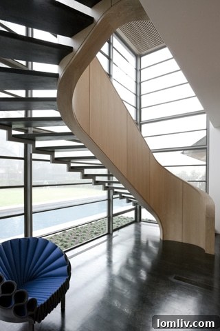 Architectural highlight: Elegant staircase with floating rift-cut white oak steps, viewed through a two-story window