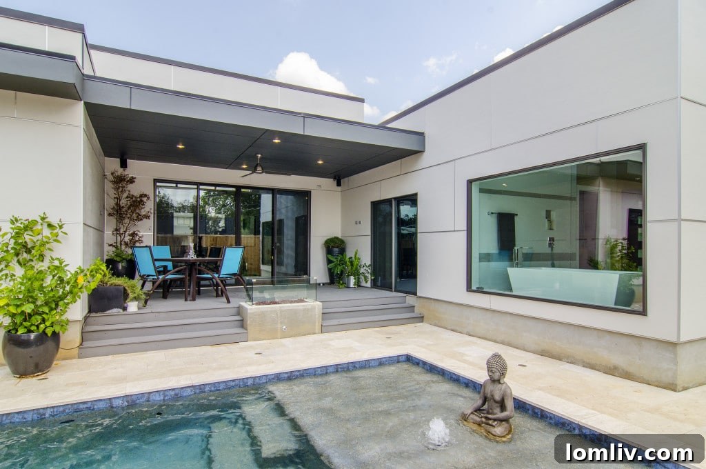 Back exterior of the modern home featuring a manicured lawn and privacy