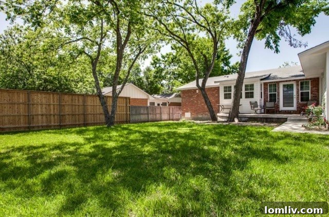Private backyard with mature trees and tall fence