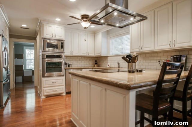 KitchenAid stainless steel appliances and island vent hood in renovated kitchen
