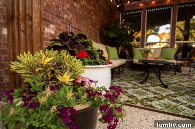 Lush container plants and vibrant flowerbeds complementing a stone patio, showcasing how greenery enhances outdoor living spaces.