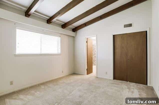 Bedroom featuring exposed wood beams, a striking midcentury architectural element