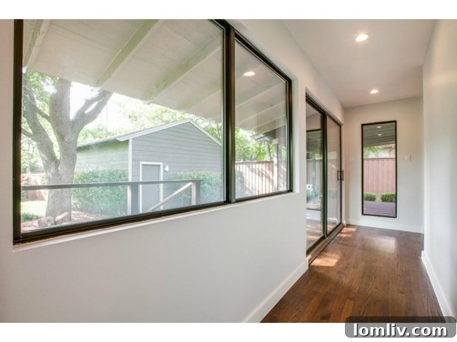 Midway Hollow Retreat: Open Layout, Wraparound Porch, and an Irresistible Master Bath 11 Well-Lit Hallway with Hardwood Floors Leading to Bedrooms