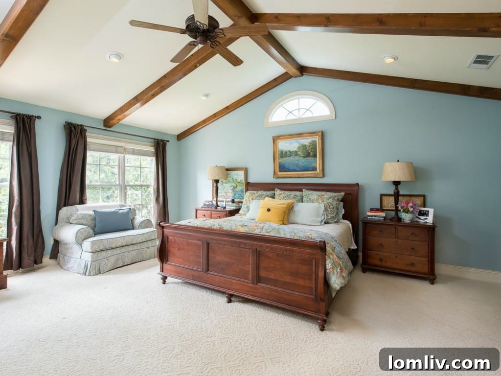 Luxurious master bedroom at 3325 Greenbrier, showcasing a cathedral ceiling with exposed beams, ample space, and refined furnishings.