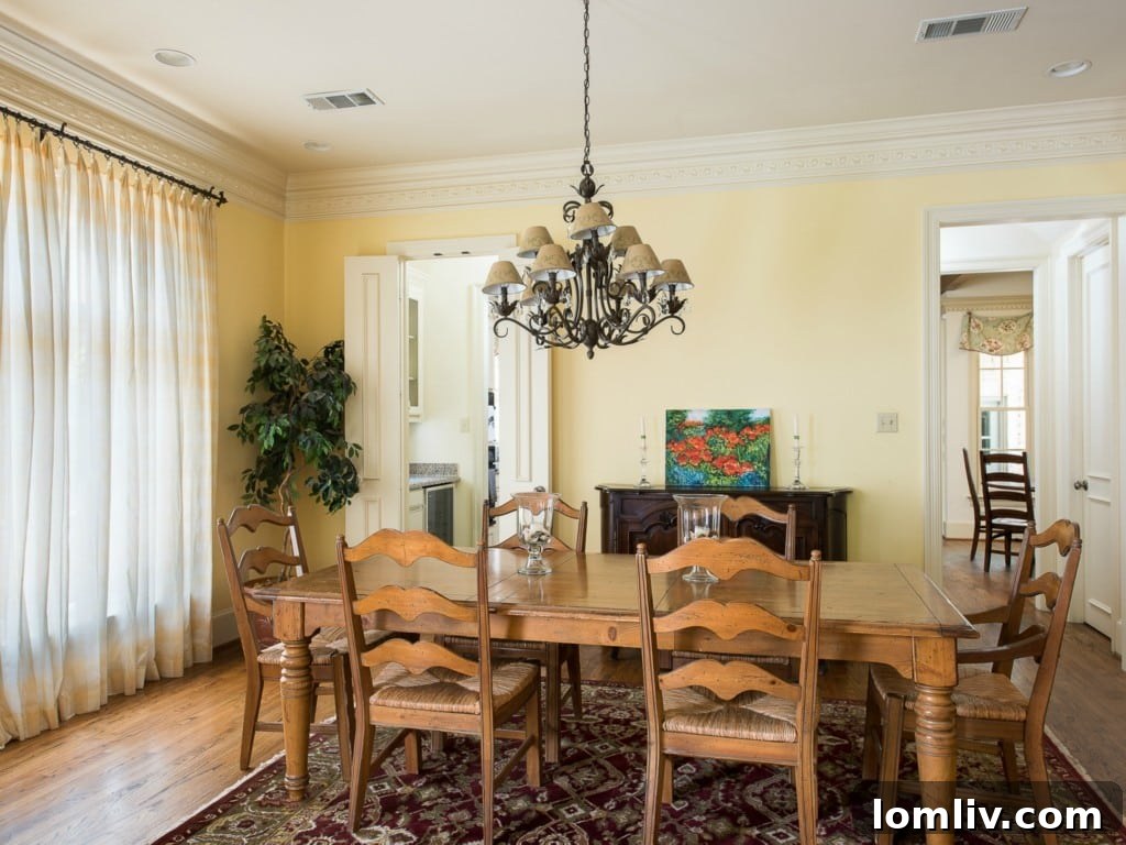 Formal dining room in 3325 Greenbrier, featuring elegant wainscoting and chandelier, ideal for entertaining guests.