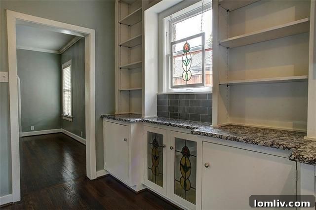 Kitchen view showing ample counter space and a vintage stained glass window accent