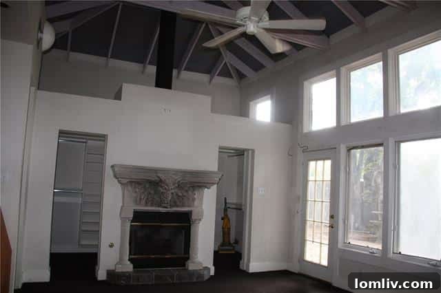 A master bedroom with a smoke-stained, tacky gargoyle fireplace, showing poor taste