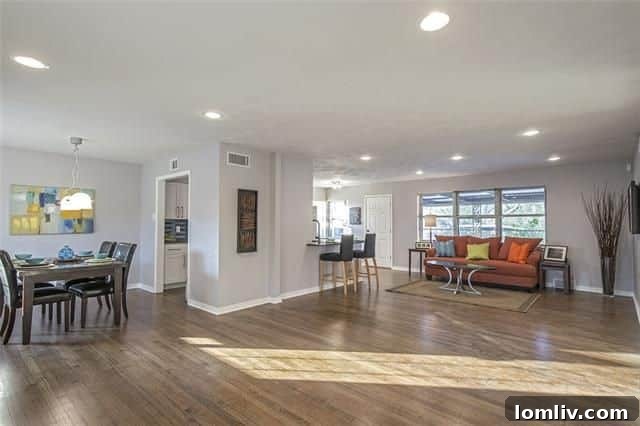 Bright and spacious living area with hardwood floors in the renovated home