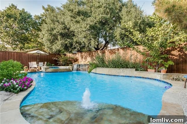 Stunning backyard oasis with swimming pool, waterfall, and outdoor kitchen