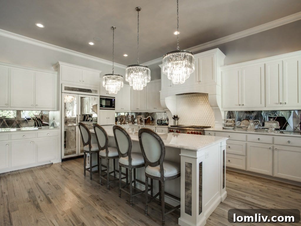 Luxury kitchen with three chandeliers and mirrored appliances in Dallas home