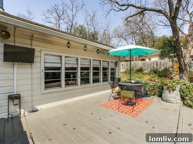 View of the back exterior, highlighting the patio and mature trees