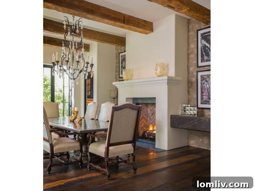 Elegant dining room with wide plank floors, fireplace, and rustic beam ceiling