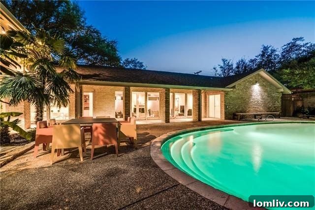Large oval swimming pool and expansive outdoor entertaining area at 6868 Meadowcreek Drive