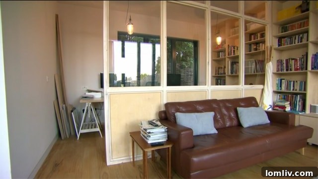 Home office with glass partition, separating it from the living area while retaining light.