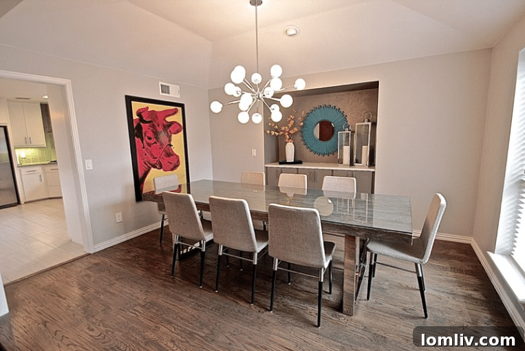 Kevin Twitty's Dream Reno Hits Market Wednesday 18 Dining room featuring an Andy Warhol print, sputnik chandelier, and a long natural wood dining table.