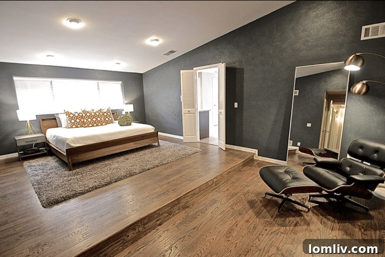 Kevin Twitty's Dream Reno Hits Market Wednesday 33 Luxurious master bedroom with a dark accent wall, low-profile bed, and an Eames chair.