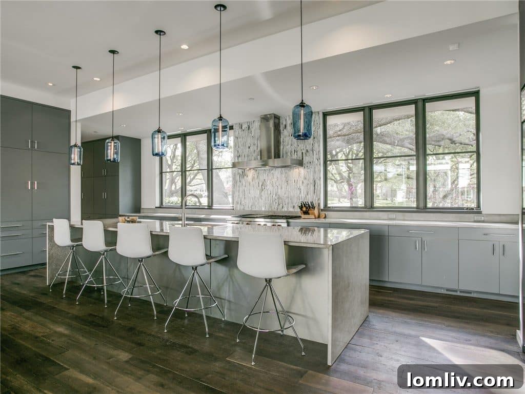 Modern kitchen with an expansive waterfall island, concrete countertops, and professional appliances.