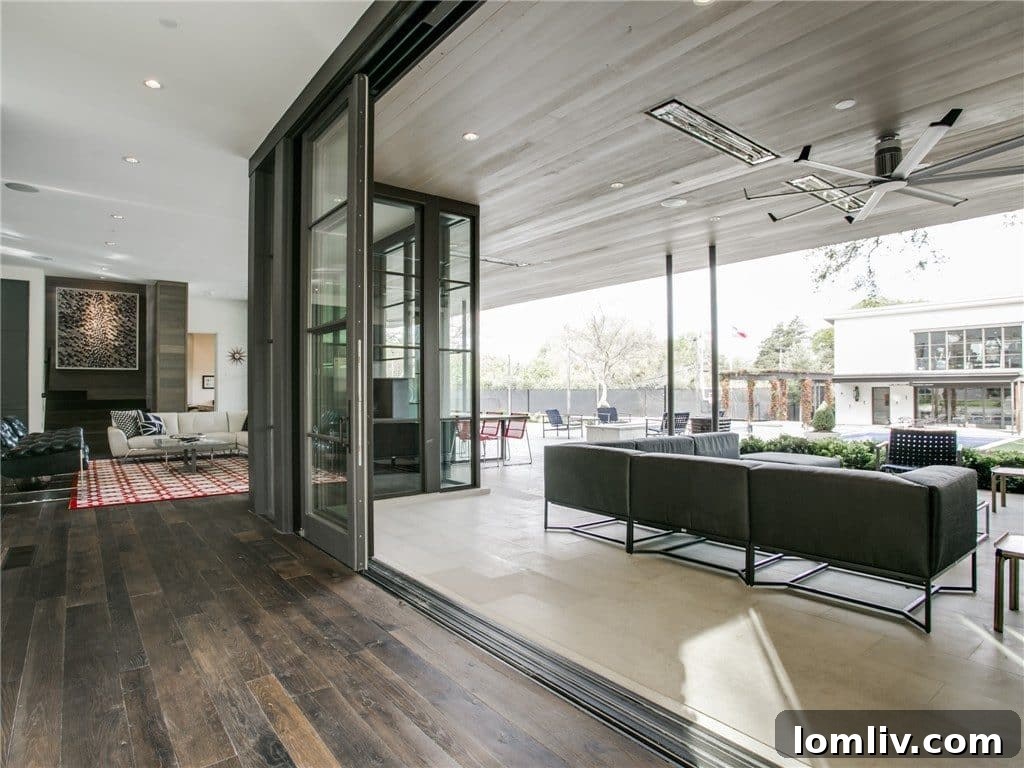 Luxurious covered outdoor porch with floor-to-ceiling sliding glass doors, seamlessly connecting to the interior.