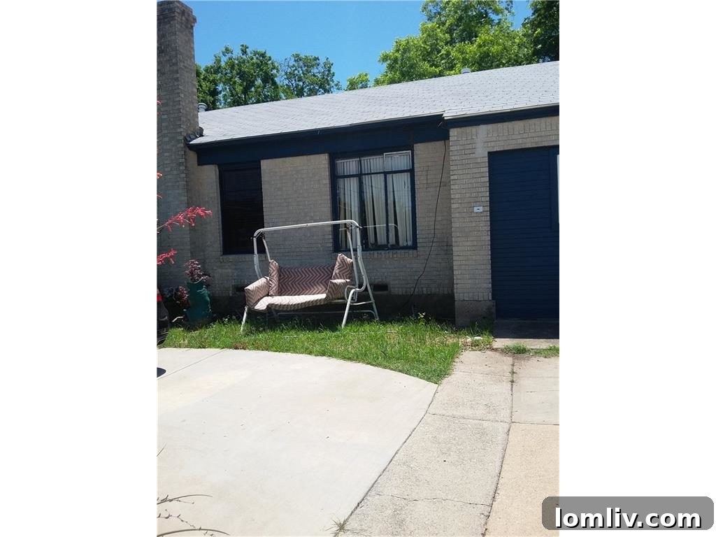 Front exterior with visible utility lines and overgrown landscaping at 655 Peavy Road