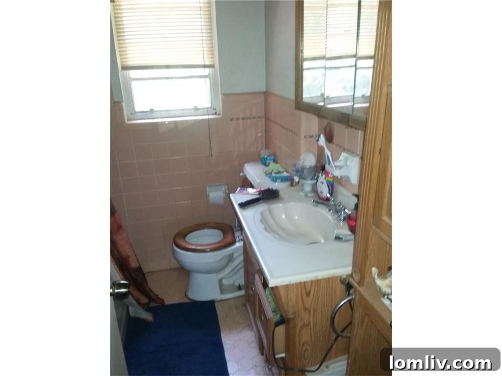 Dated bathroom featuring a unique shell-shaped sink and excessive clutter