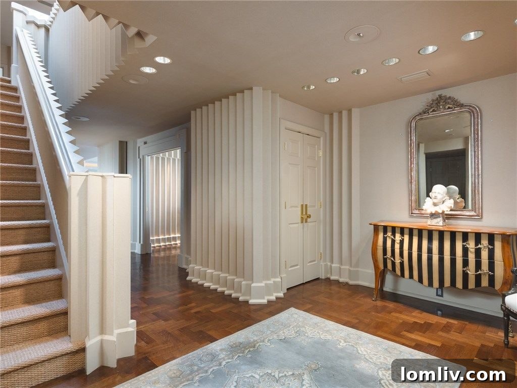 Elegant entryway with herringbone wood floors and dramatic lighting, hinting at the home's unique design.