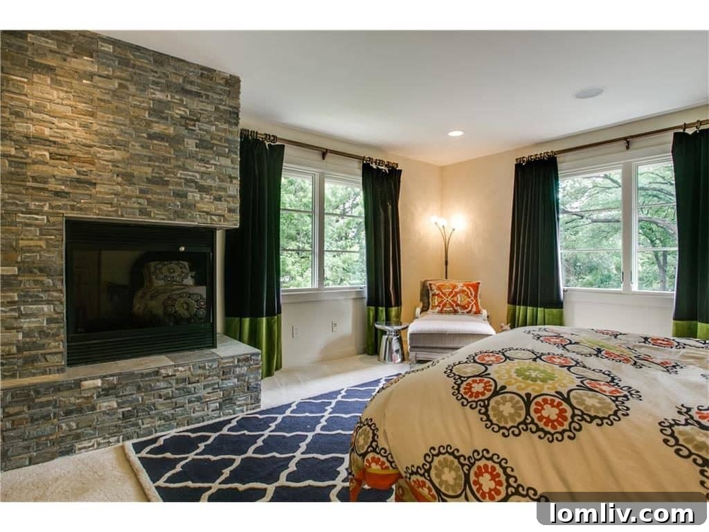 Second-floor bedroom with large windows offering panoramic views of trees and greenbelt