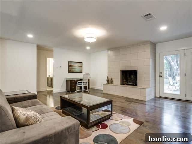 Bright and open living room with a contemporary tiled fireplace and large windows overlooking the backyard.