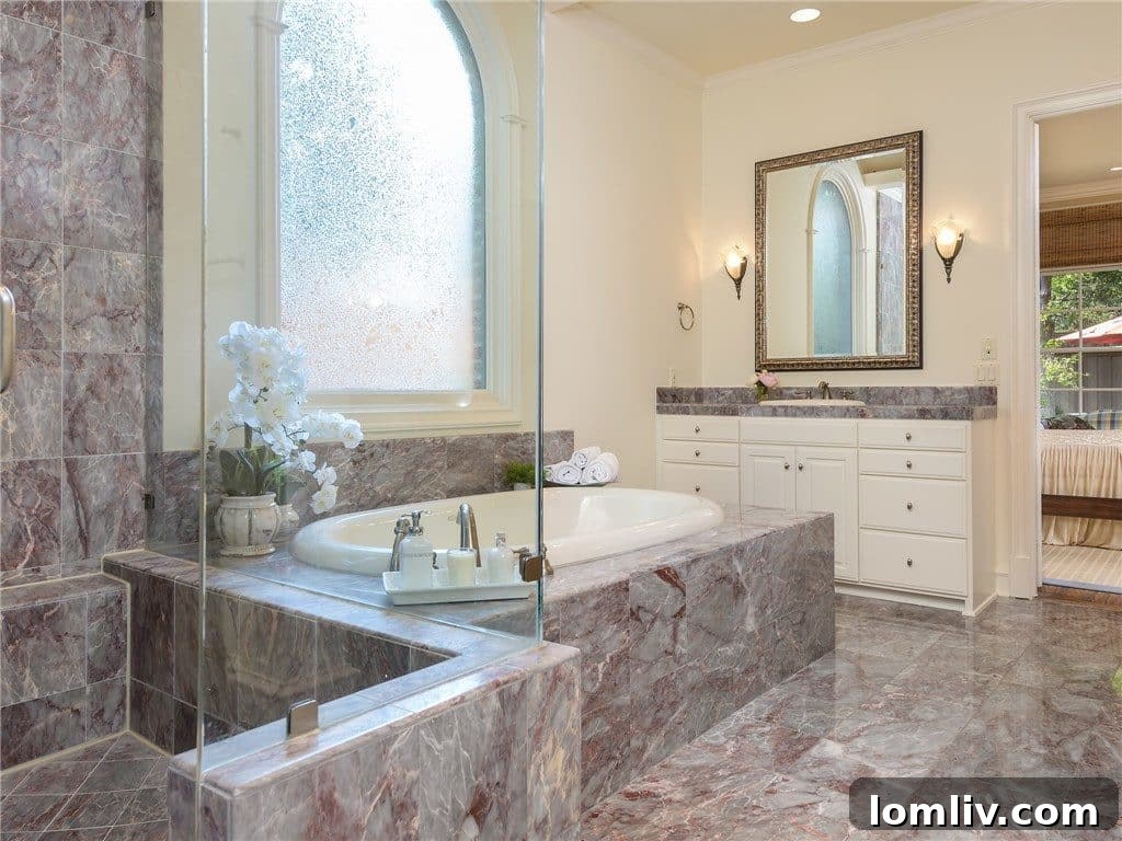 Opulent master bathroom with dual marble vanities and elegant fixtures