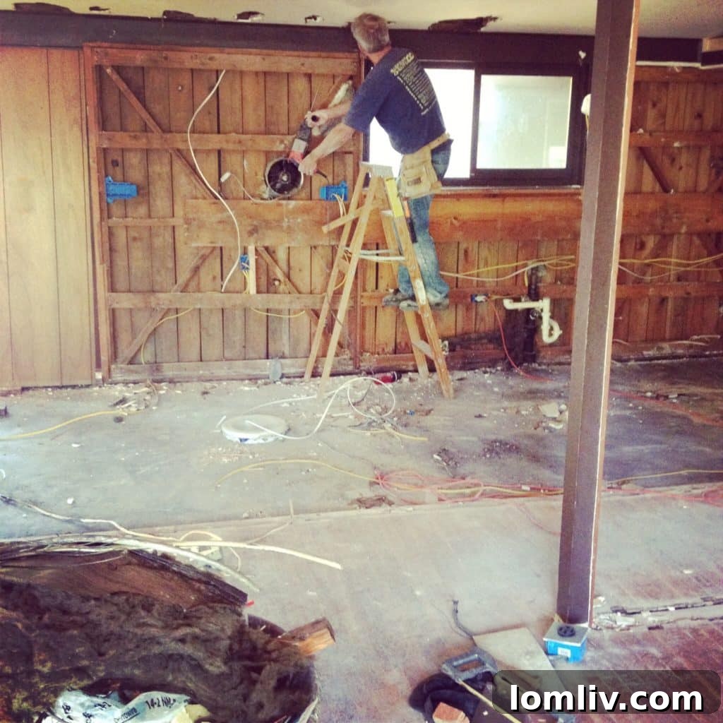 The kitchen during the early stages of renovation, showing bare floors and walls