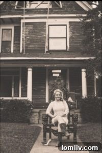 Realtor Kristen Martin standing proudly in front of her meticulously renovated Victorian home in Old East Dallas.
