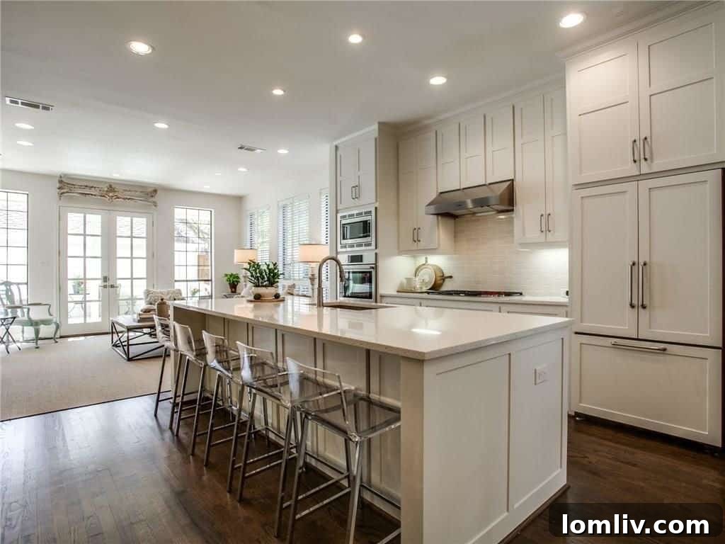 Close-up of the elegant kitchen featuring white cabinetry, quartz countertops, and high-end appliances