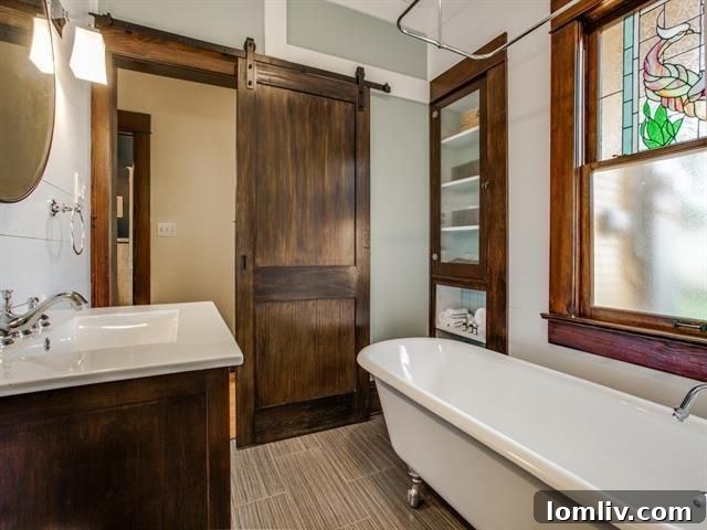 Luxurious master bathroom with clawfoot tub and stained glass.