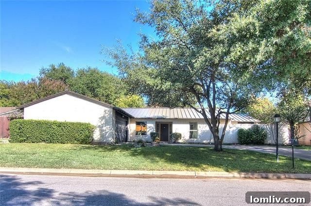 Sleek, modern kitchen with waterfall island in Prestonwood home.