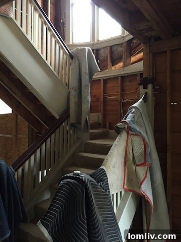 Detailed view of the beautifully restored staircase at 2300 Willing Avenue, highlighting ebony treads and crisp white balusters