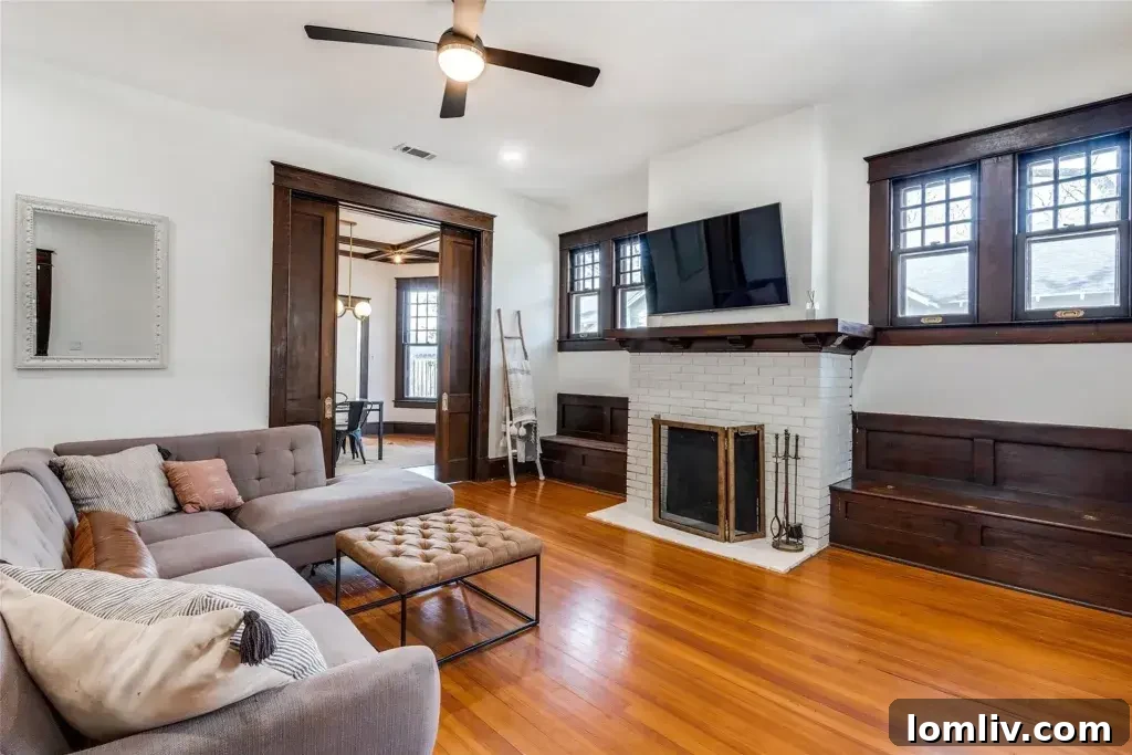 A cozy living room in a Winnetka Heights Craftsman home, featuring a fireplace flanked by original built-in storage benches and classic millwork.