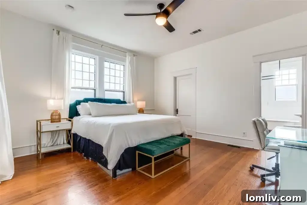A luxurious ensuite bathroom in a historic Winnetka Heights home, featuring a classic claw-foot tub and a pedestal sink, maintaining vintage elegance.