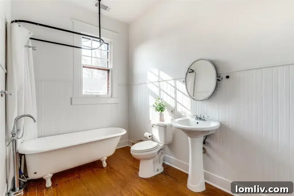 A spacious and elegantly appointed bedroom in a Winnetka Heights Craftsman home, showcasing ample natural light and period-appropriate decor.