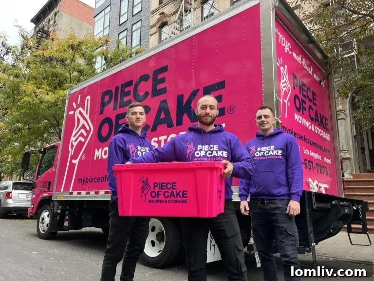 Professional movers carrying boxes with pink Piece of Cake Moving branding in NYC