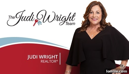 Judi Wright Forged Her Future In Real Estate Against All Odds 3 Judi Wright, surrounded by her dedicated real estate team members, smiles brightly in their professional office.