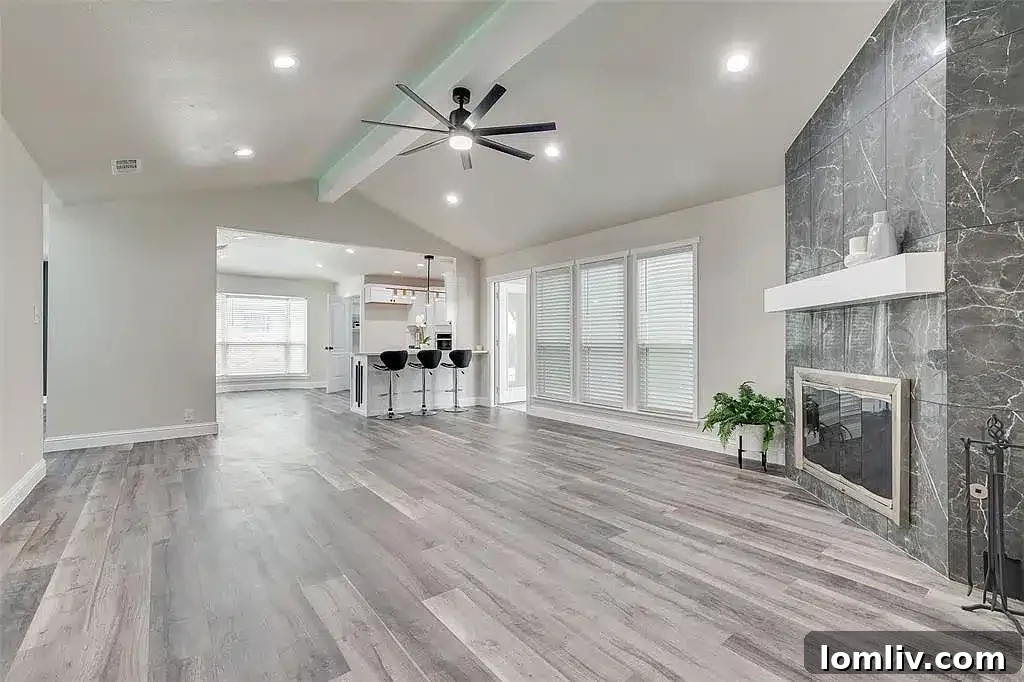 A modern and elegant kitchen in the renovated Plano home, with white cabinets and a large island.