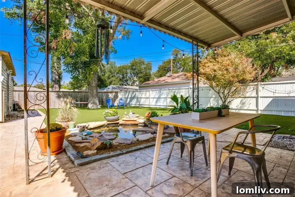 A serene backyard featuring a covered patio, a natural stone water feature, and low-maintenance synthetic grass, providing a perfect outdoor retreat.