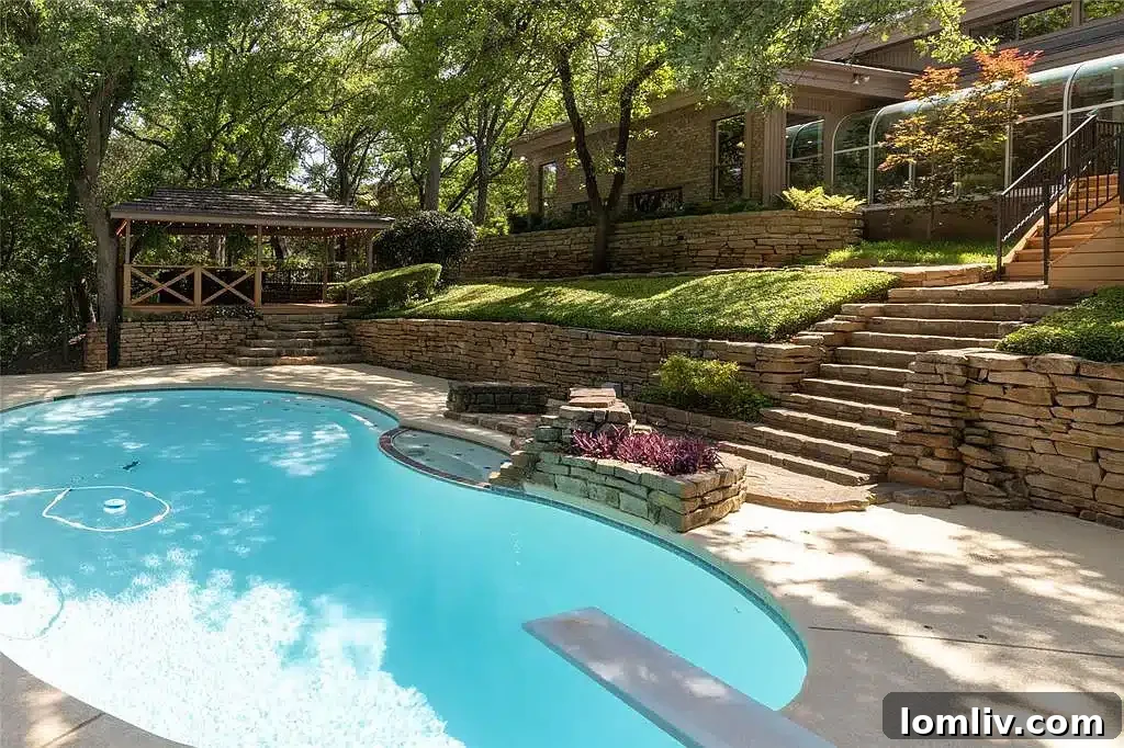 Swimming pool and lush landscaping at a wooded property
