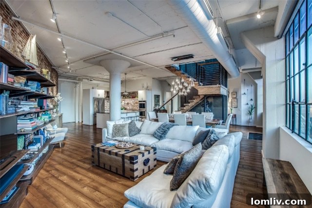 Bright, open-plan loft interior with large windows and modern furnishings